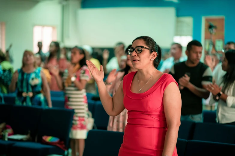 a woman talking into a microphone in front of a group of people