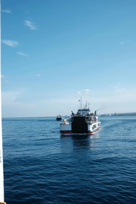 two boats in the blue water are in the distance