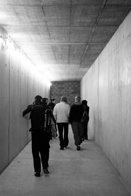 a group of people are walking in an underpass