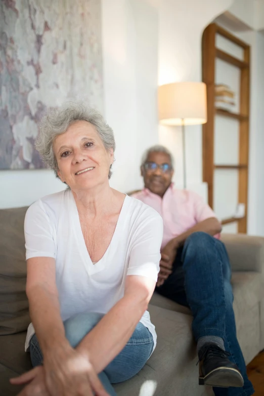 two elderly people sitting on a couch together