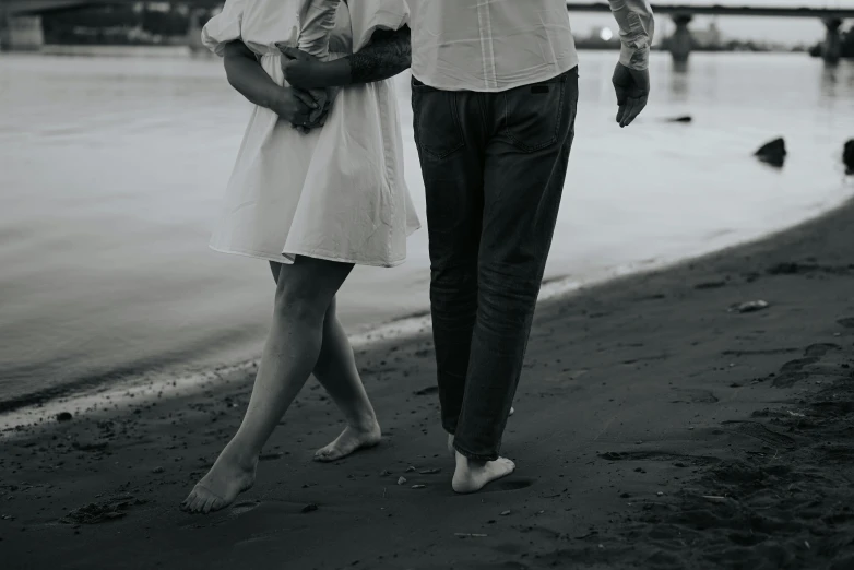 black and white pograph of a couple walking by the water