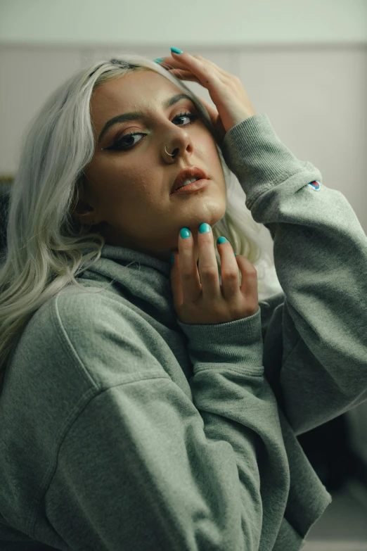a woman with long grey hair wearing teal nails