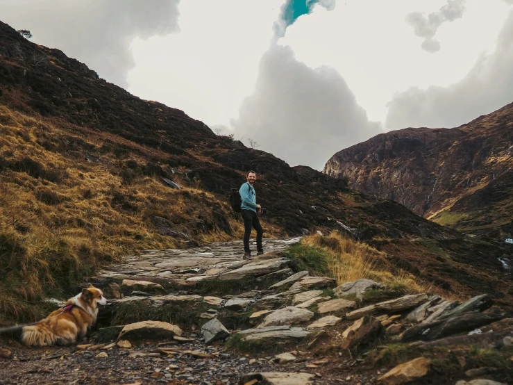 a man in blue jacket walking up some steps with dog