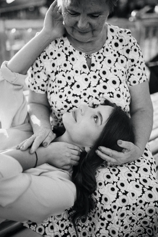 woman in pajamas holding small girl looking at cellphone