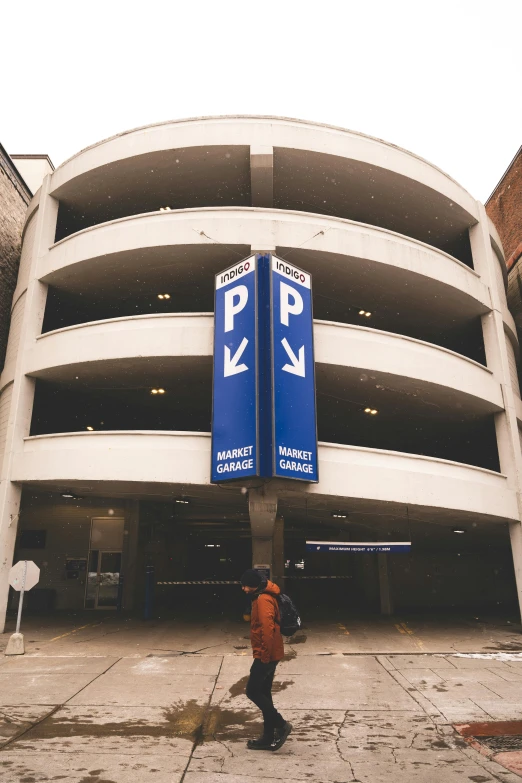 the parking sign stands tall in front of a huge building