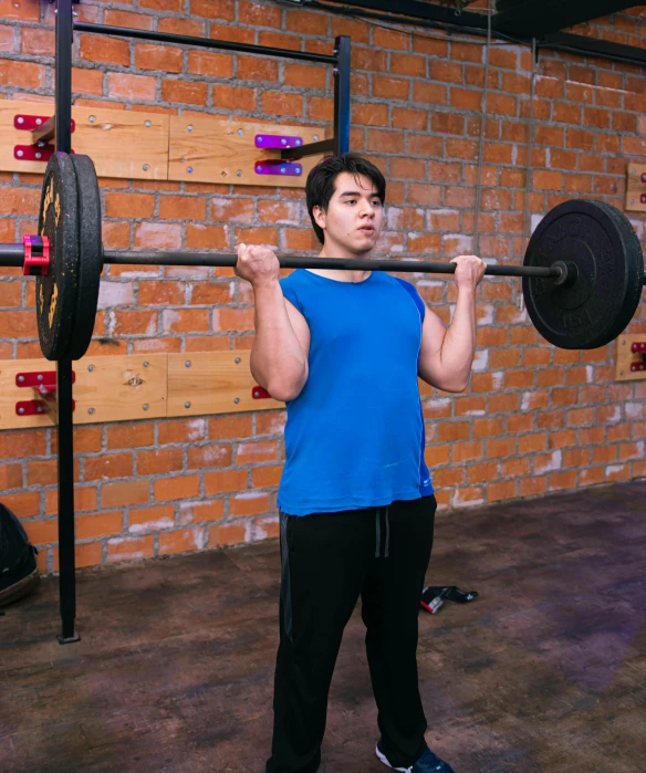 a man is standing in a garage while lifting a bar