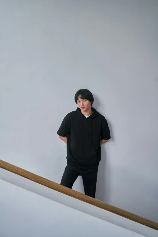 a boy standing next to a rail and some stairs