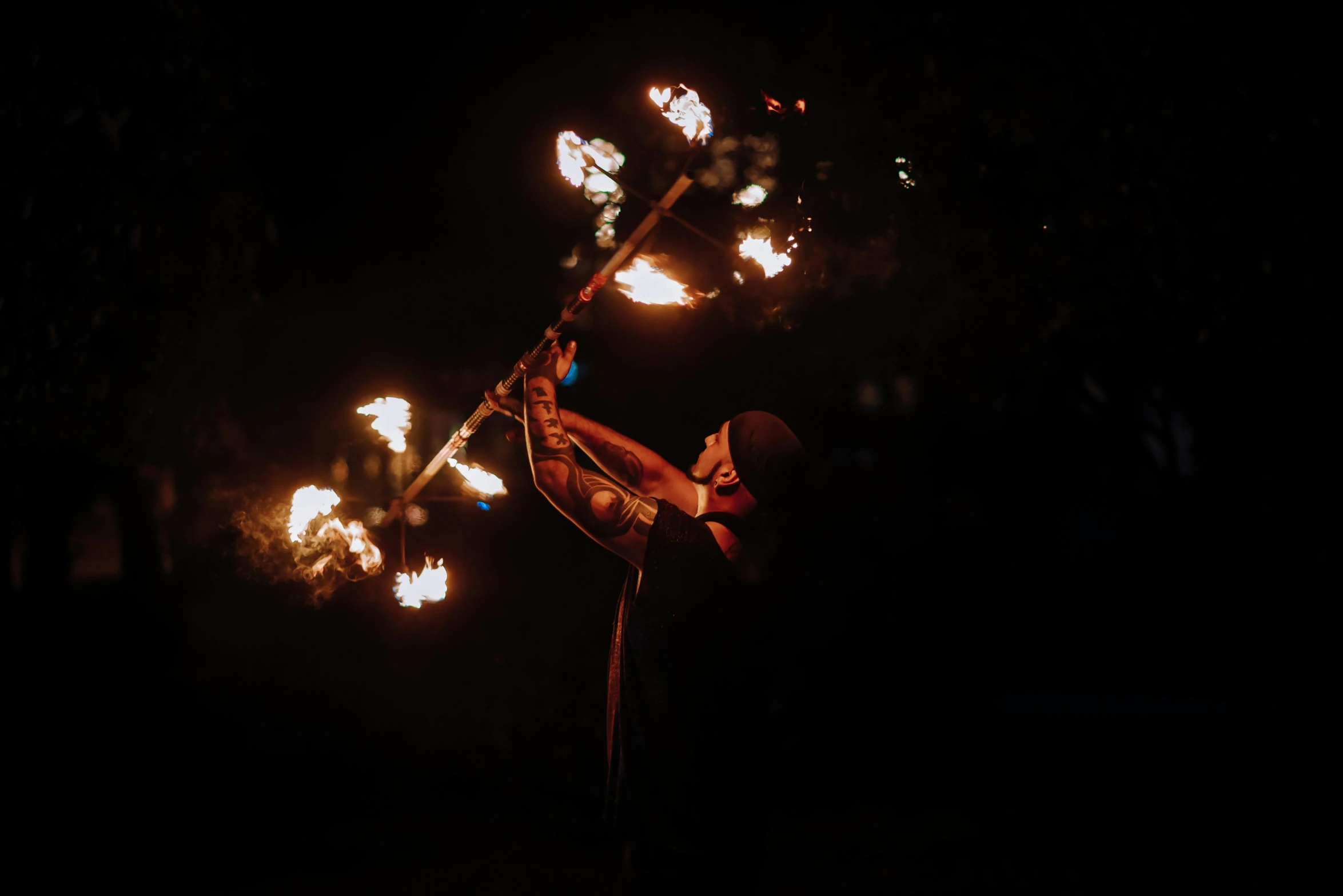 an individual performs aerial acrobatic acrobatic tricks with torches