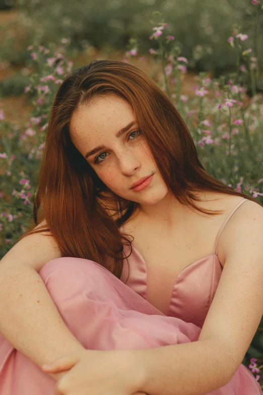 a girl in a pink dress is looking at the camera