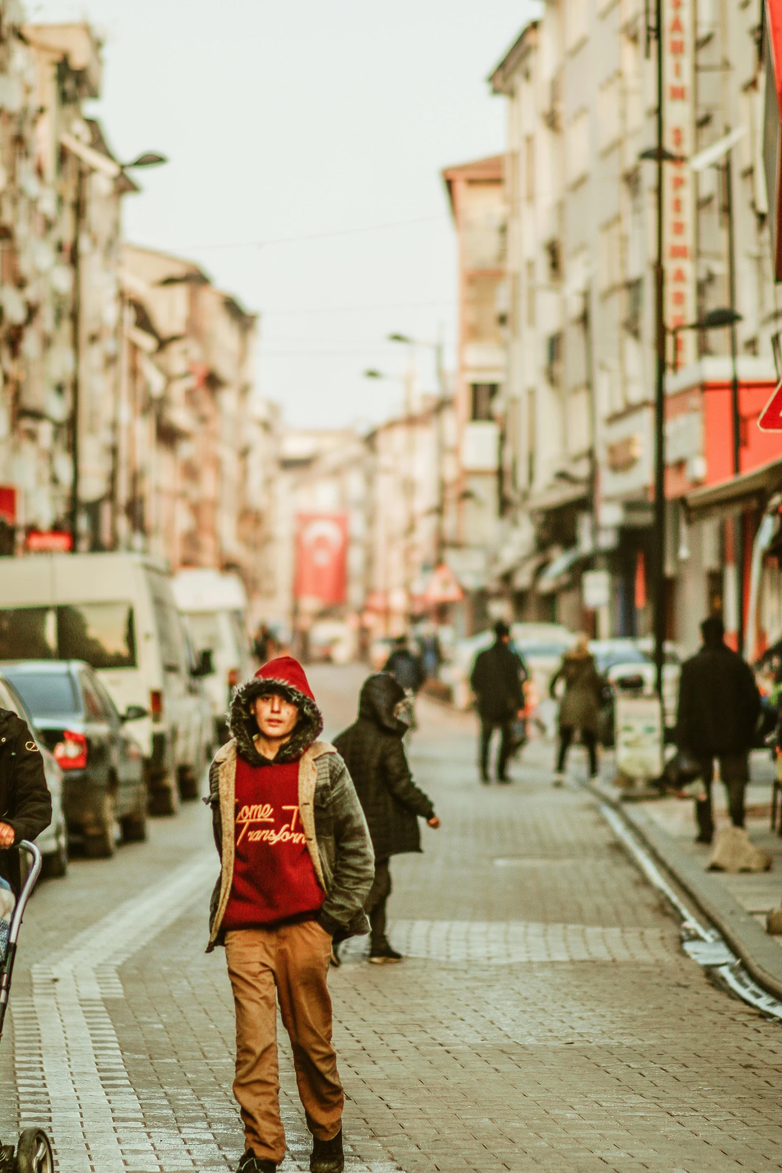 a person walking down a street with a stroller on a sidewalk