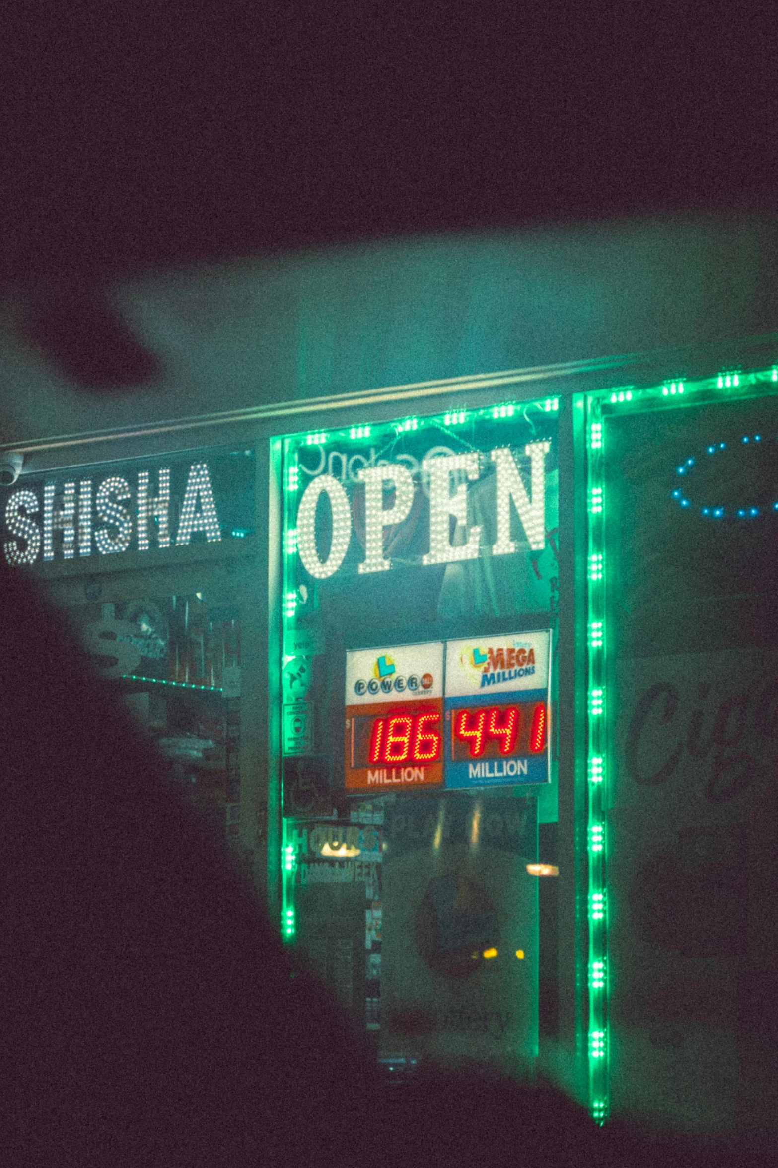 an open sign covered in green lights