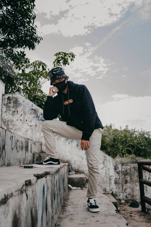 man smoking a cigarette leaning on a wall