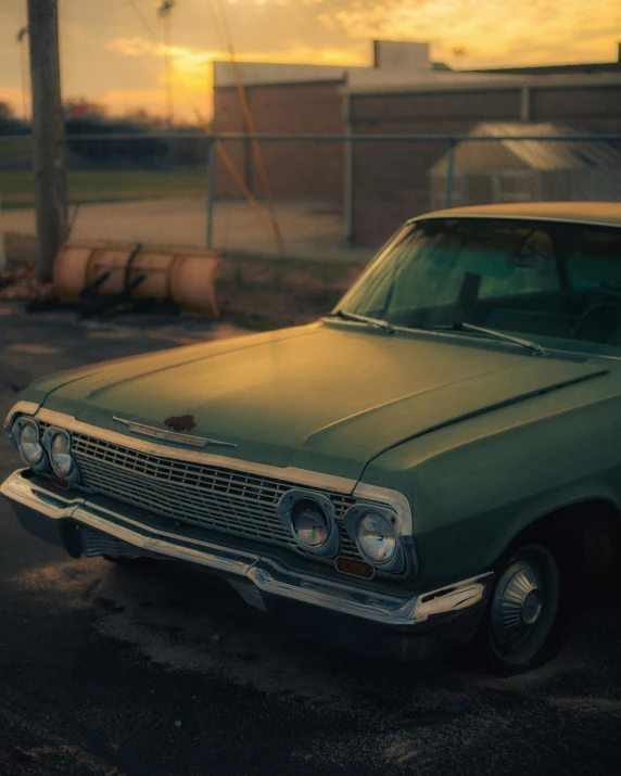 an old green car is parked on the street