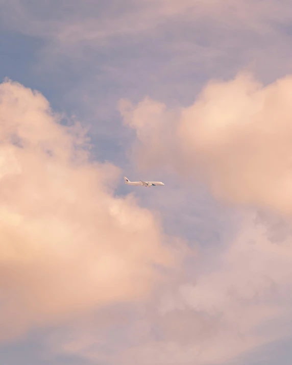 an airplane flying in the blue sky and clouds