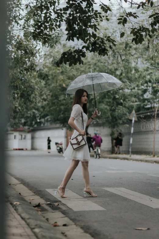 a woman in white dress holding a black and white umbrella