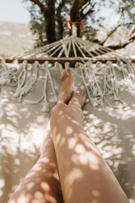 someone relaxing in a hammock with their feet up and their hands on the ground