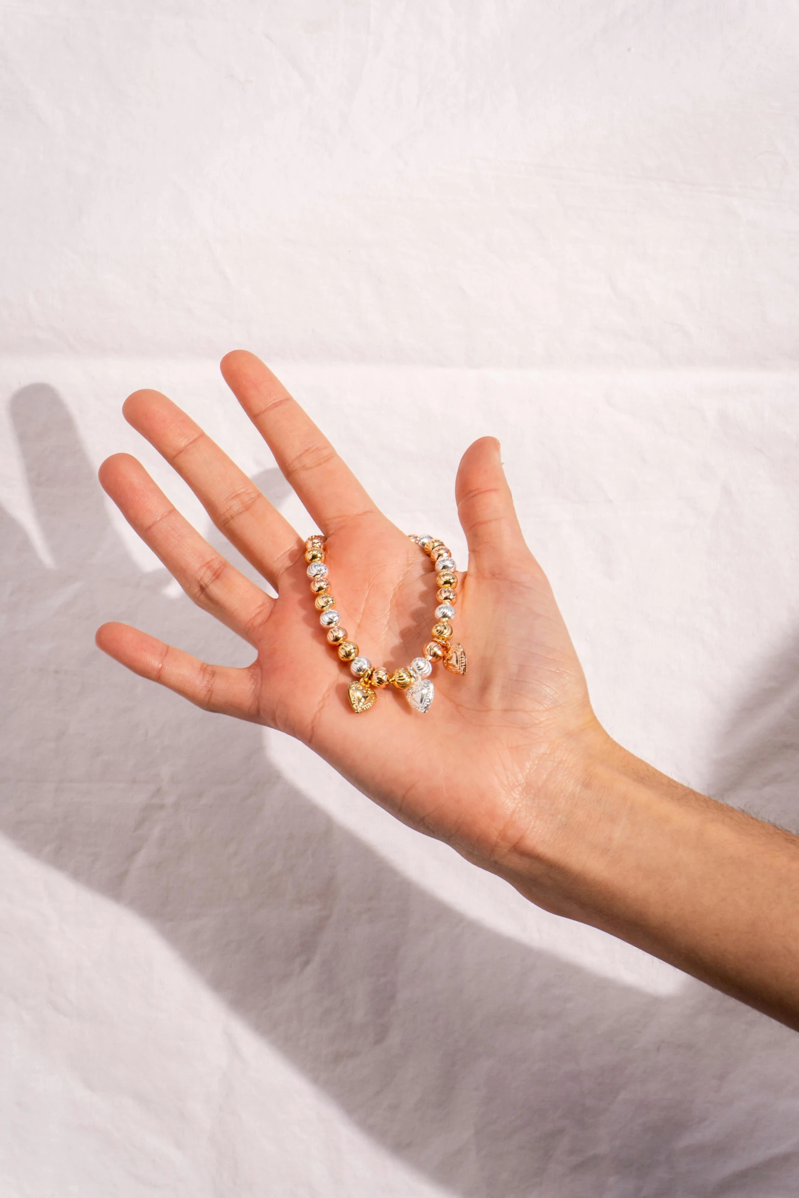 a person holding out their hand with two golden beads