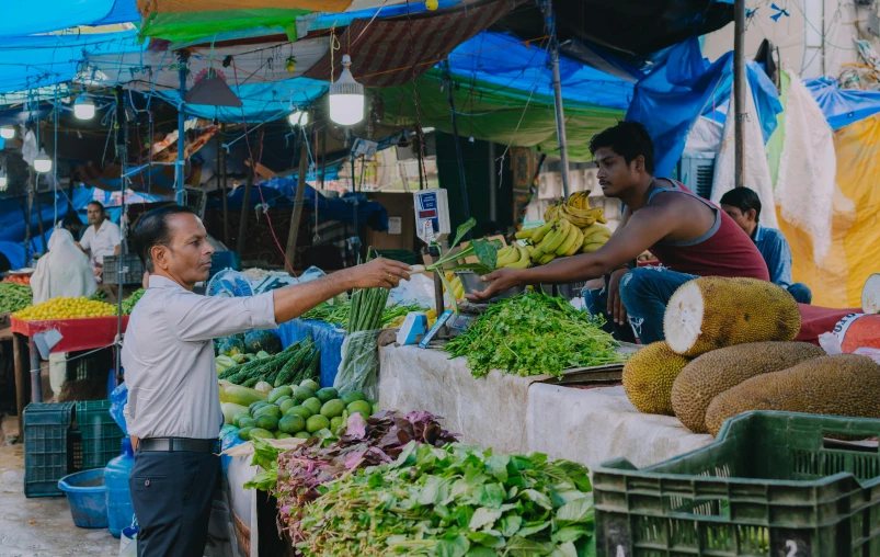 a man is standing near an outdoor market