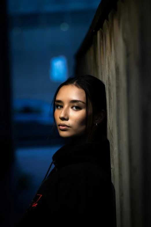 woman in the dark against a wall