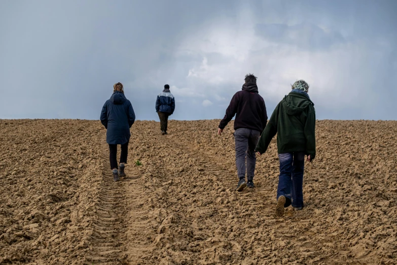 three people walking in the sand holding hands