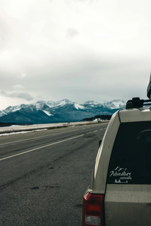 a van on the side of the road with mountains in the background