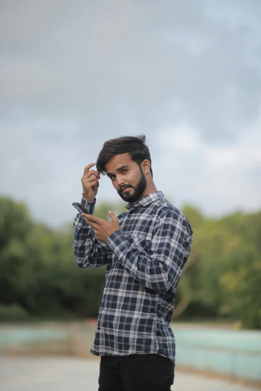 a man standing in a park next to a tree