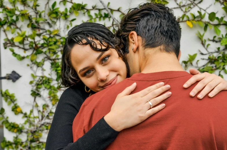 there is a woman hugging a man on the cheek