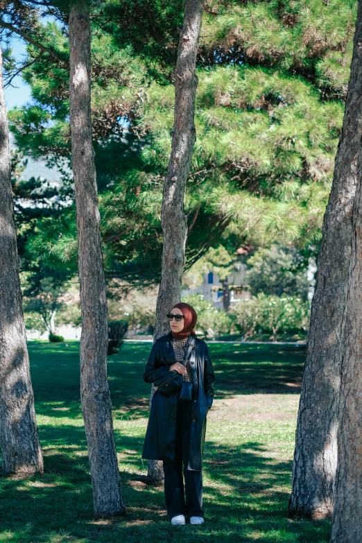 the man is standing in the park near trees