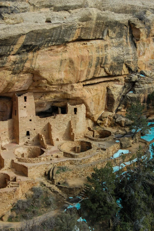 some buildings on a cliff side with blue water