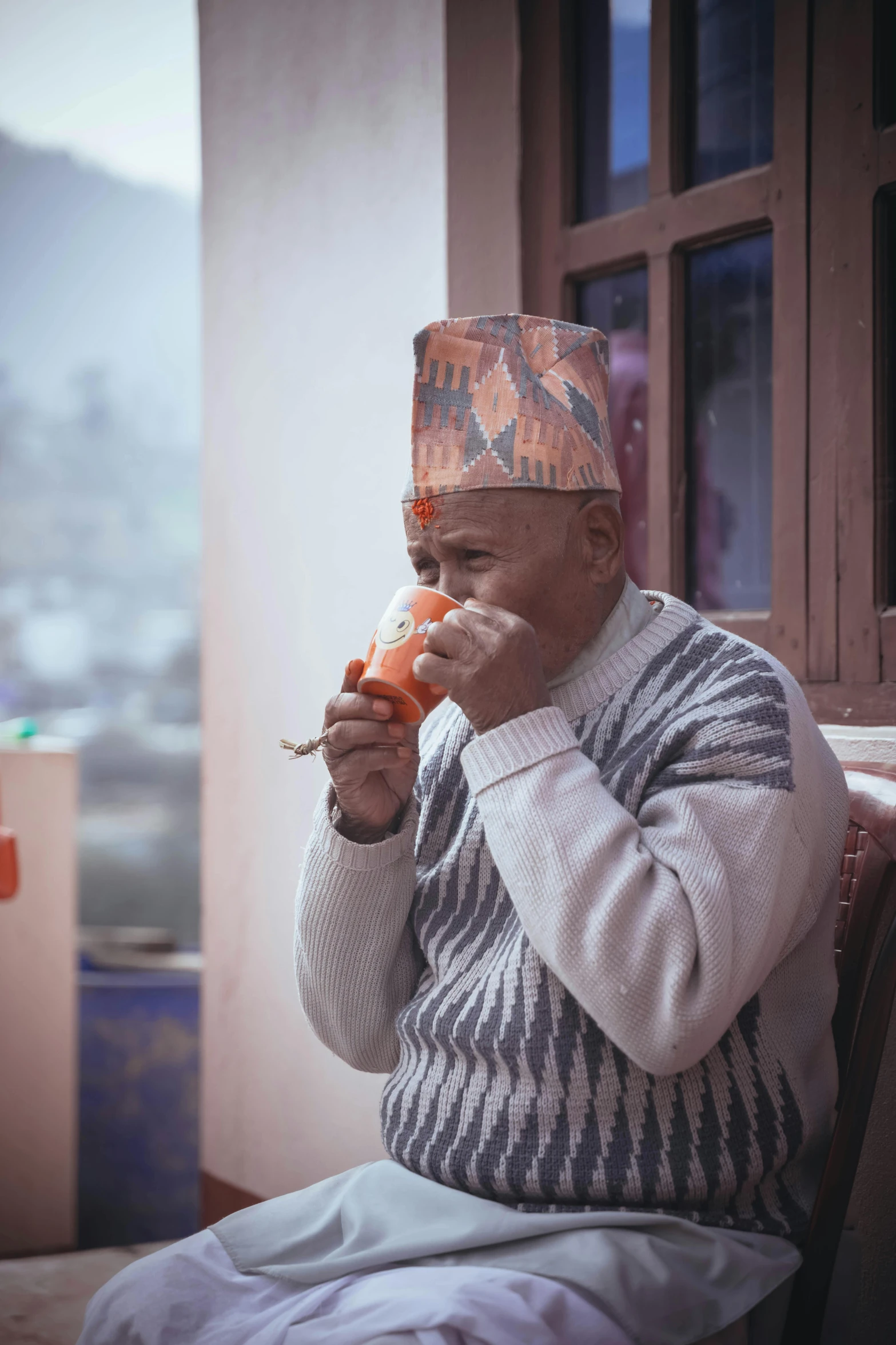 a man in a sweater and a hat eating food