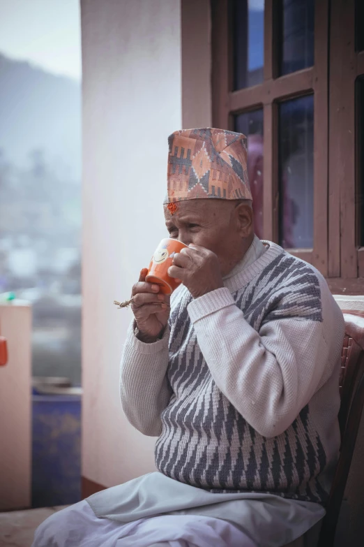 a man in a sweater and a hat eating food