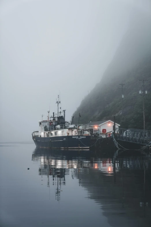 a small tug boat in a foggy body of water