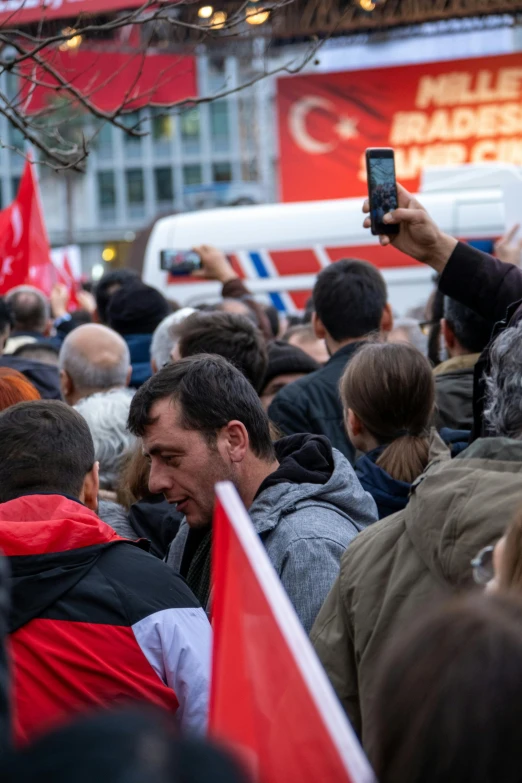 people with cell phones walk in a crowd of people