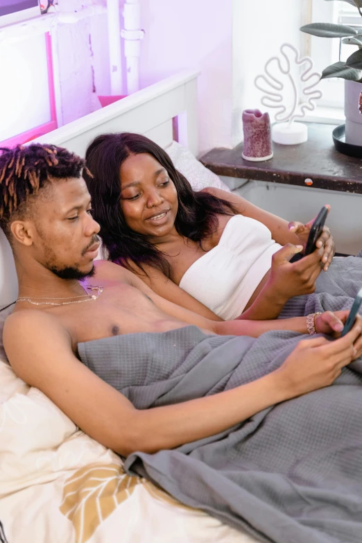 a man and woman looking at the screen on their cell phones