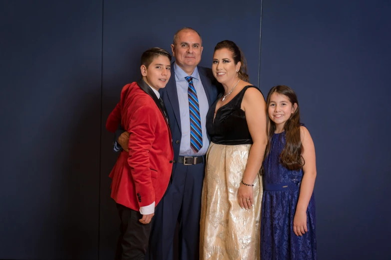 a family standing in front of a blue wall