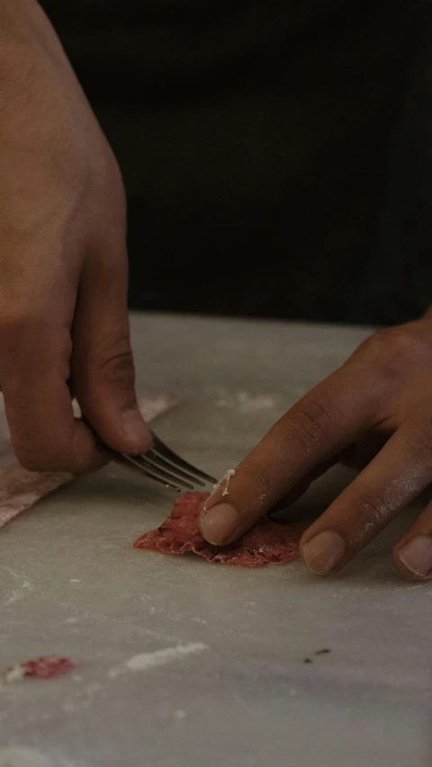 person  up meat with a knife and fork