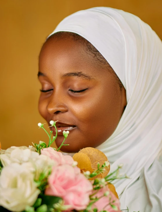 a young woman is smelling a flower bouquet