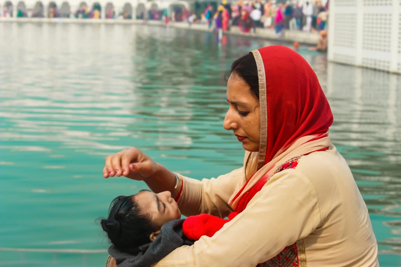 a woman with a small child at the waters edge