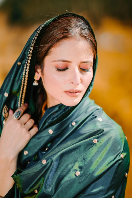 a woman with a green veil and jewelry