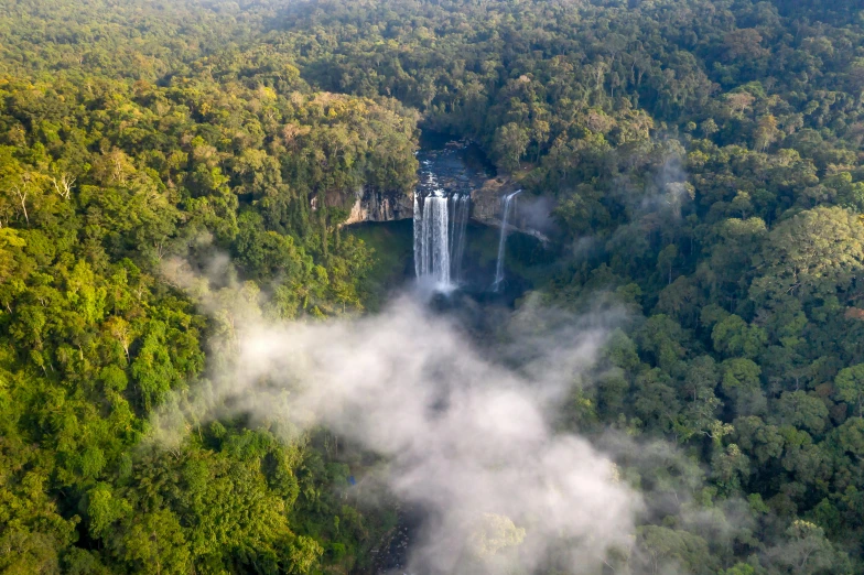 an aerial view of a waterfall surrounded by trees