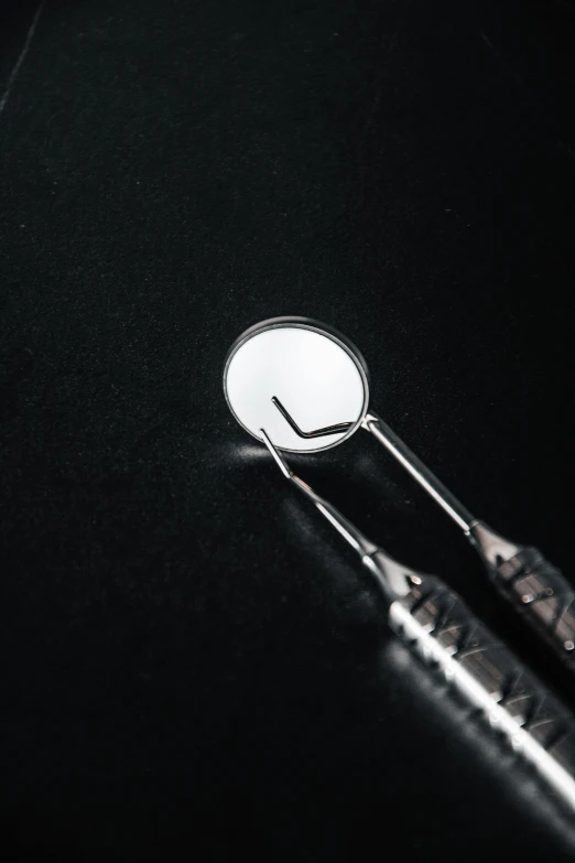 two surgical instruments sitting side by side in the dark