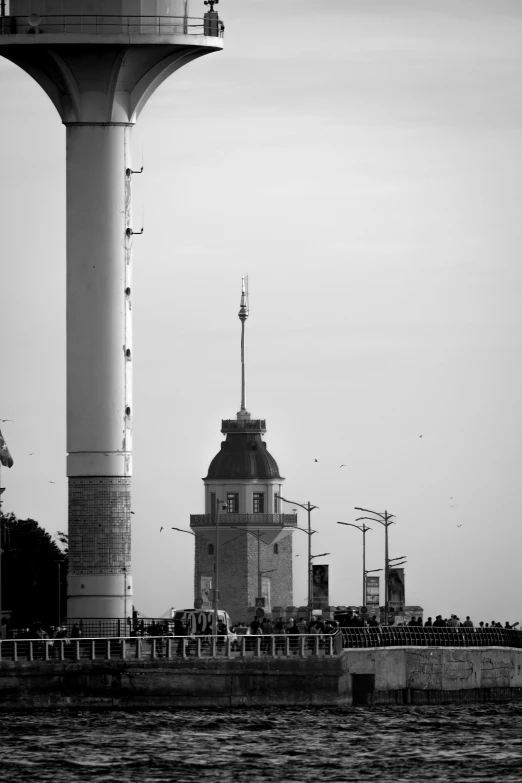 a tower sits in the water in front of a body of water