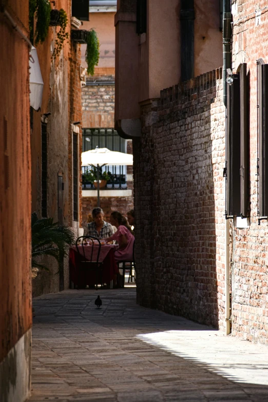 people sitting at a table in an alley way