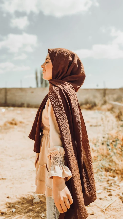 an old model in a head covering stands outside