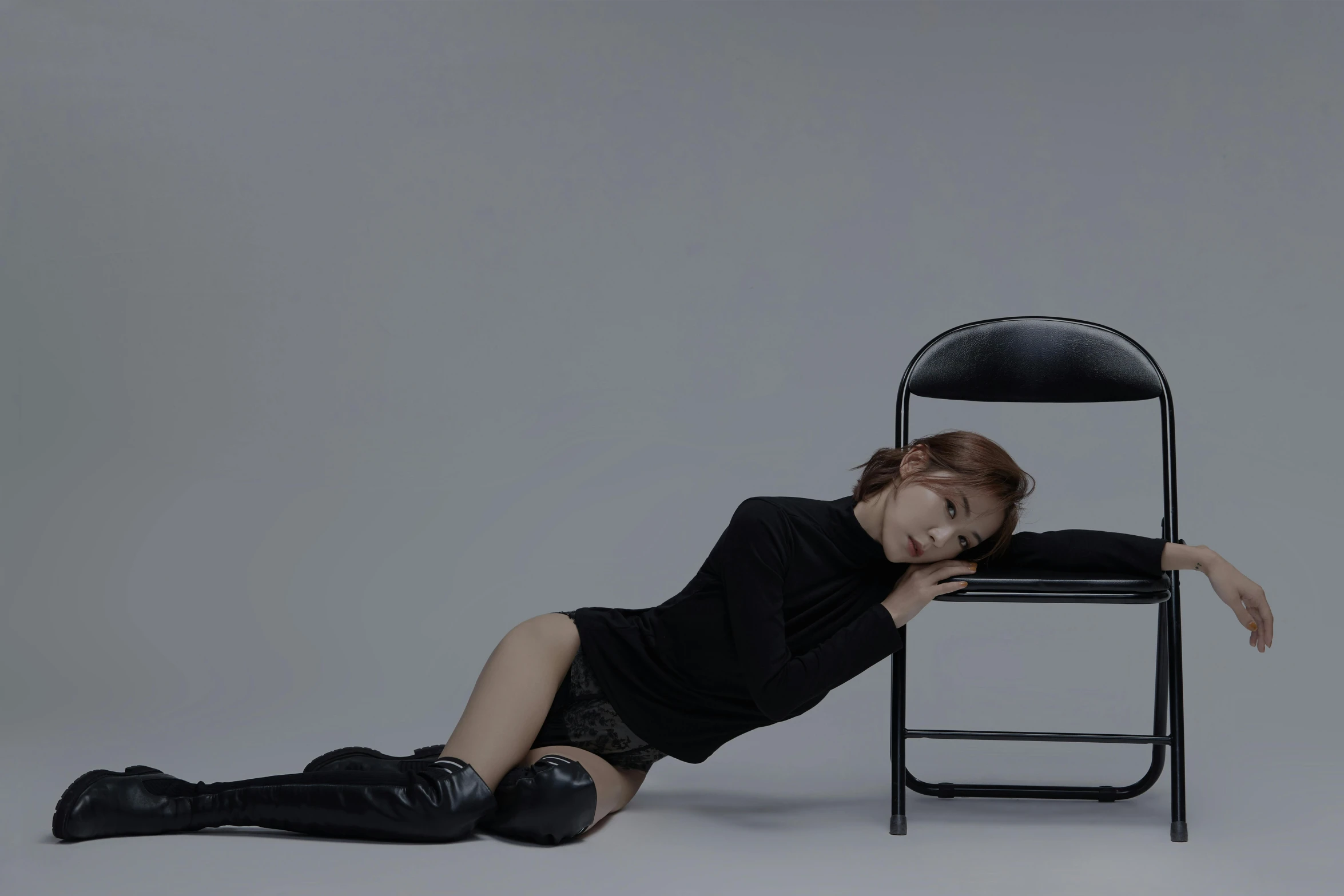 a woman laying on the ground next to a chair