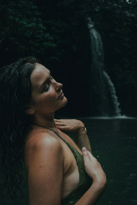 a beautiful woman in a bikini near a waterfall