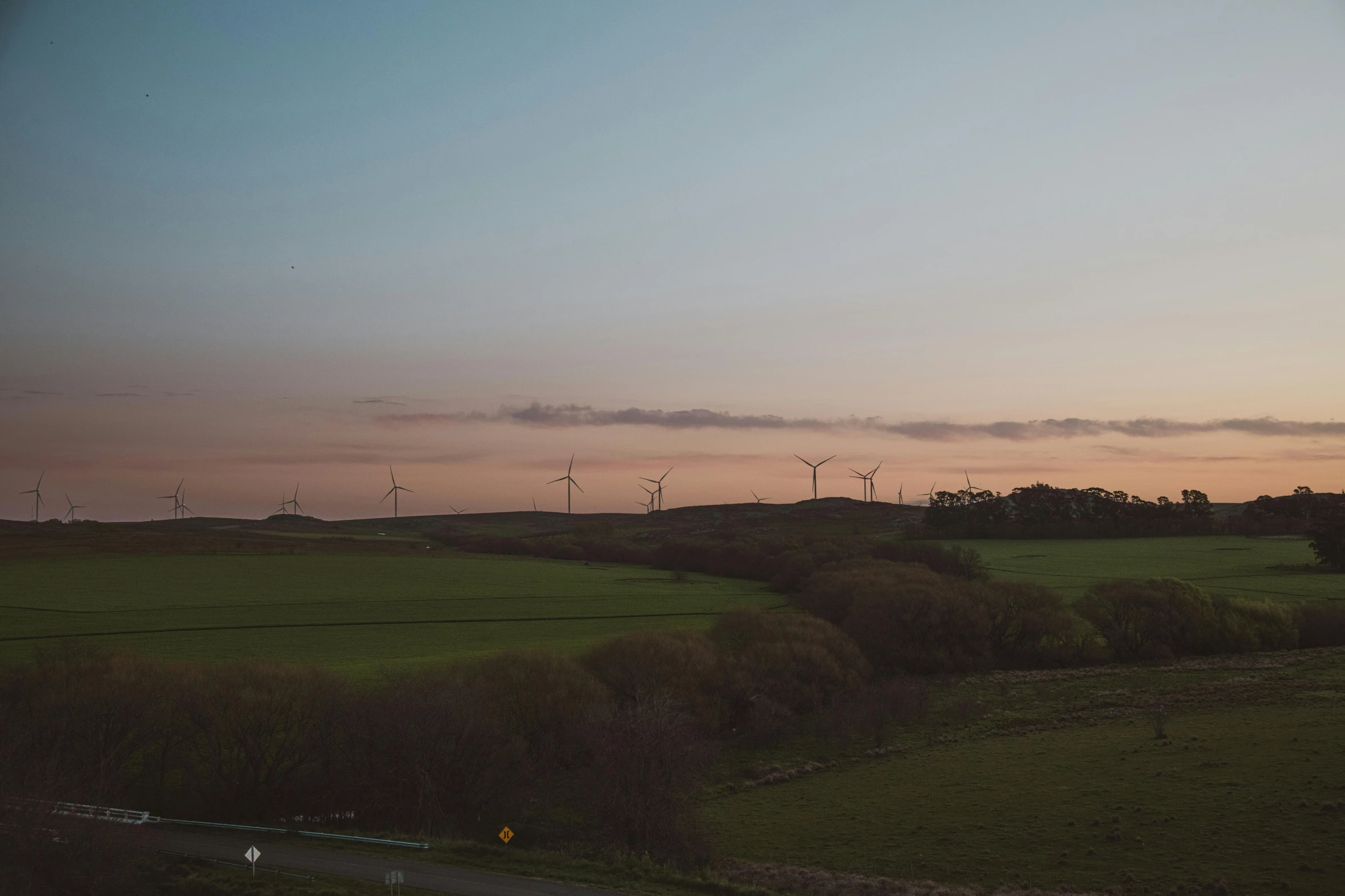 a few windmills sit on top of a field