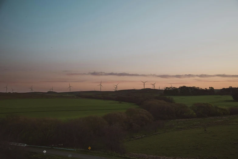 a few windmills sit on top of a field