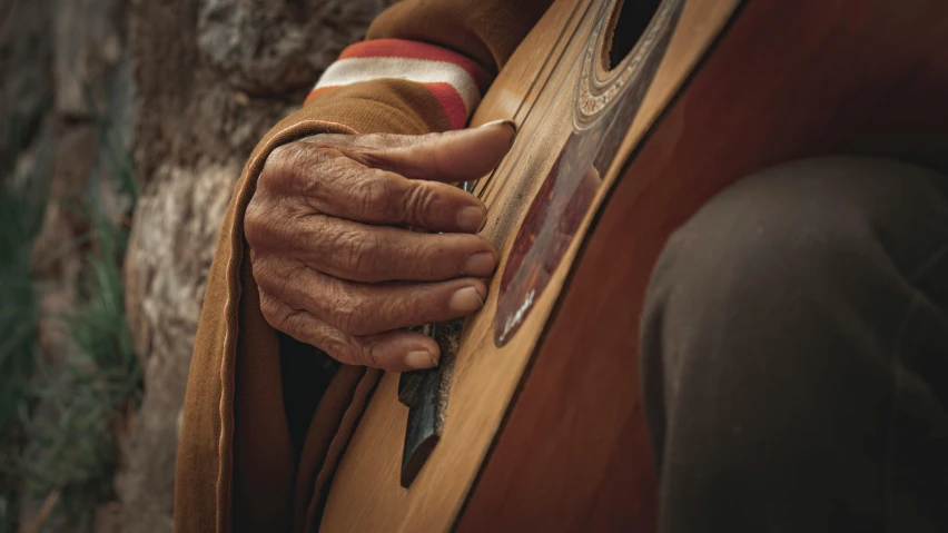 an old woman holding her hand on a guitar