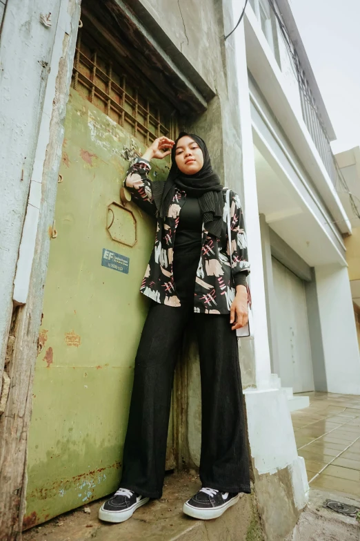 a woman leaning on the side of a building